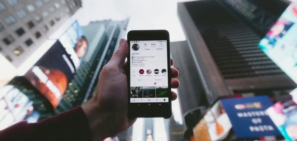 An image of someone holding phone showing social media platform. Photo by Jakob Owens on Unsplash